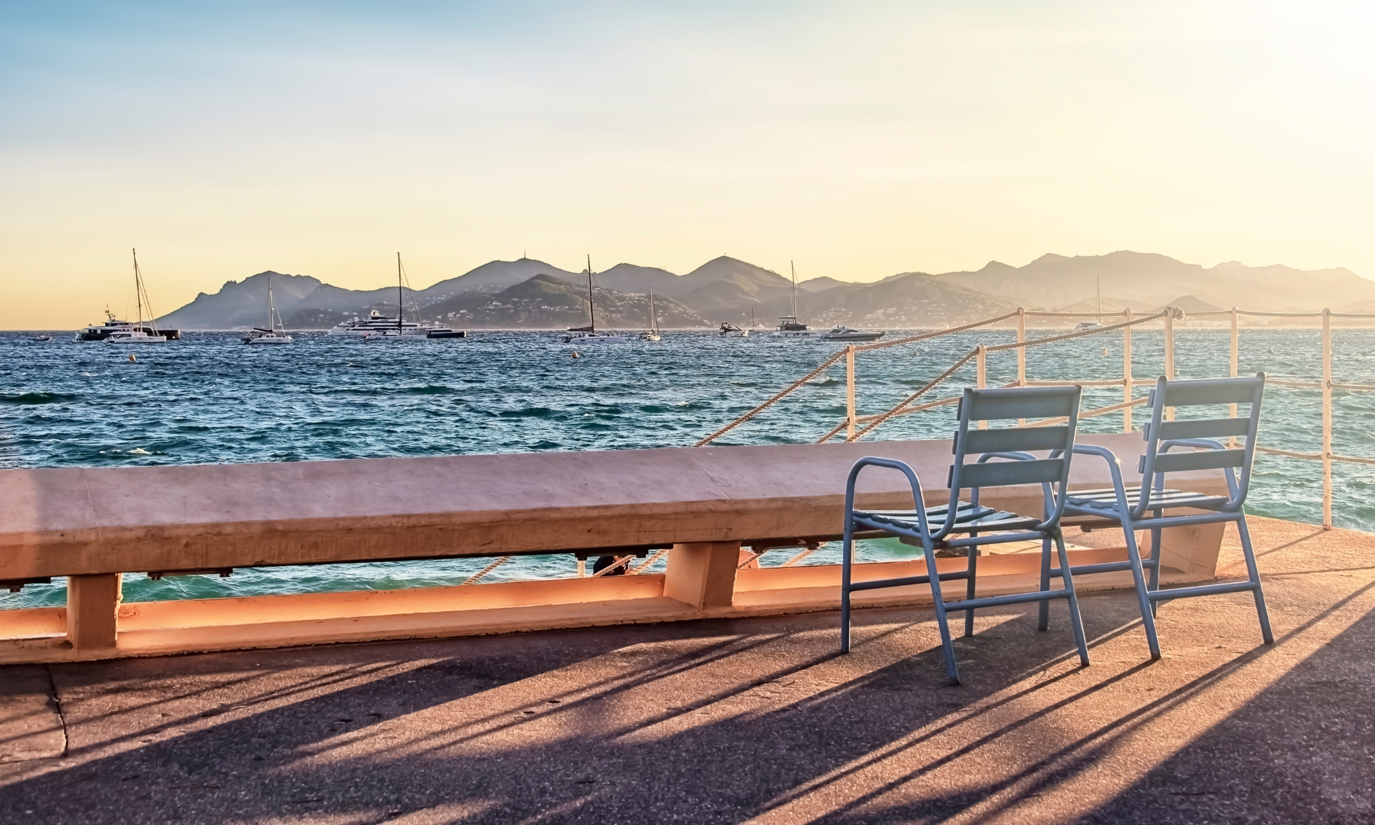 Vue sur la mer avec des chaises bleues à Cannes
